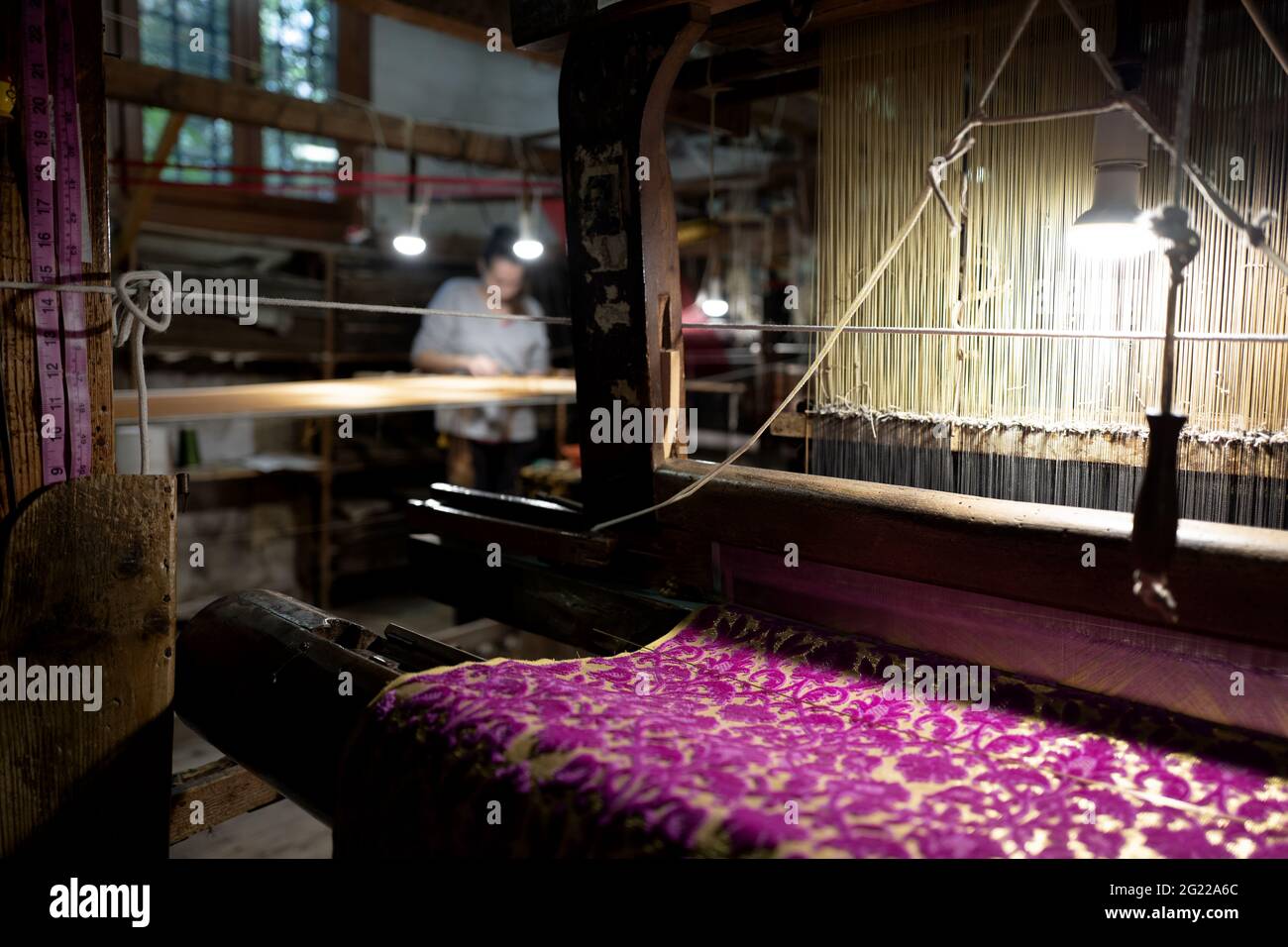 Une travailleuse au tissage fait à la main historique Luigi Bevilacqua, ils produisent des tissus fins pour le mobilier et la haute mode, à Venise, en Italie Banque D'Images