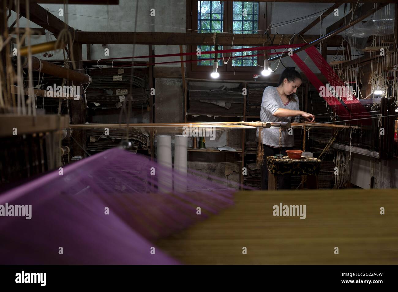 Une travailleuse au tissage fait à la main historique Luigi Bevilacqua, ils produisent des tissus fins pour le mobilier et la haute mode, à Venise, en Italie Banque D'Images