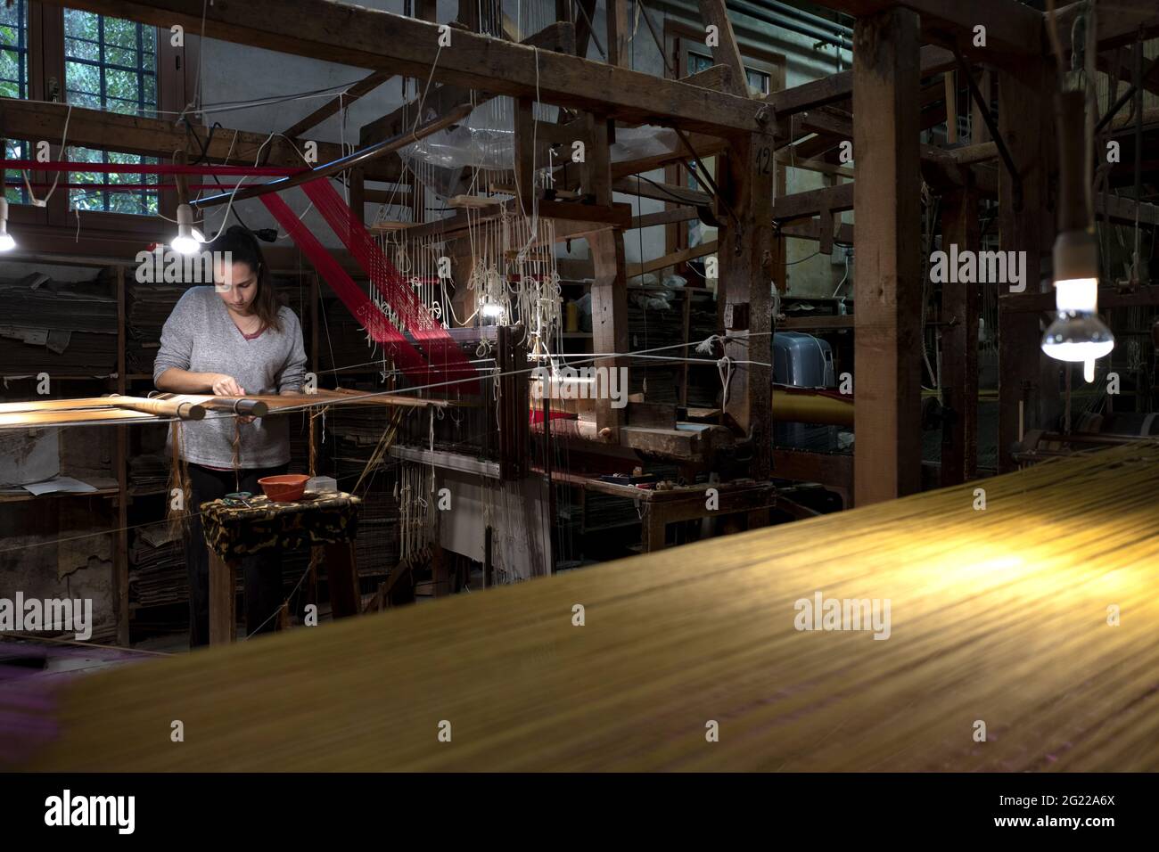 Une travailleuse au tissage fait à la main historique Luigi Bevilacqua, ils produisent des tissus fins pour le mobilier et la haute mode, à Venise, en Italie Banque D'Images