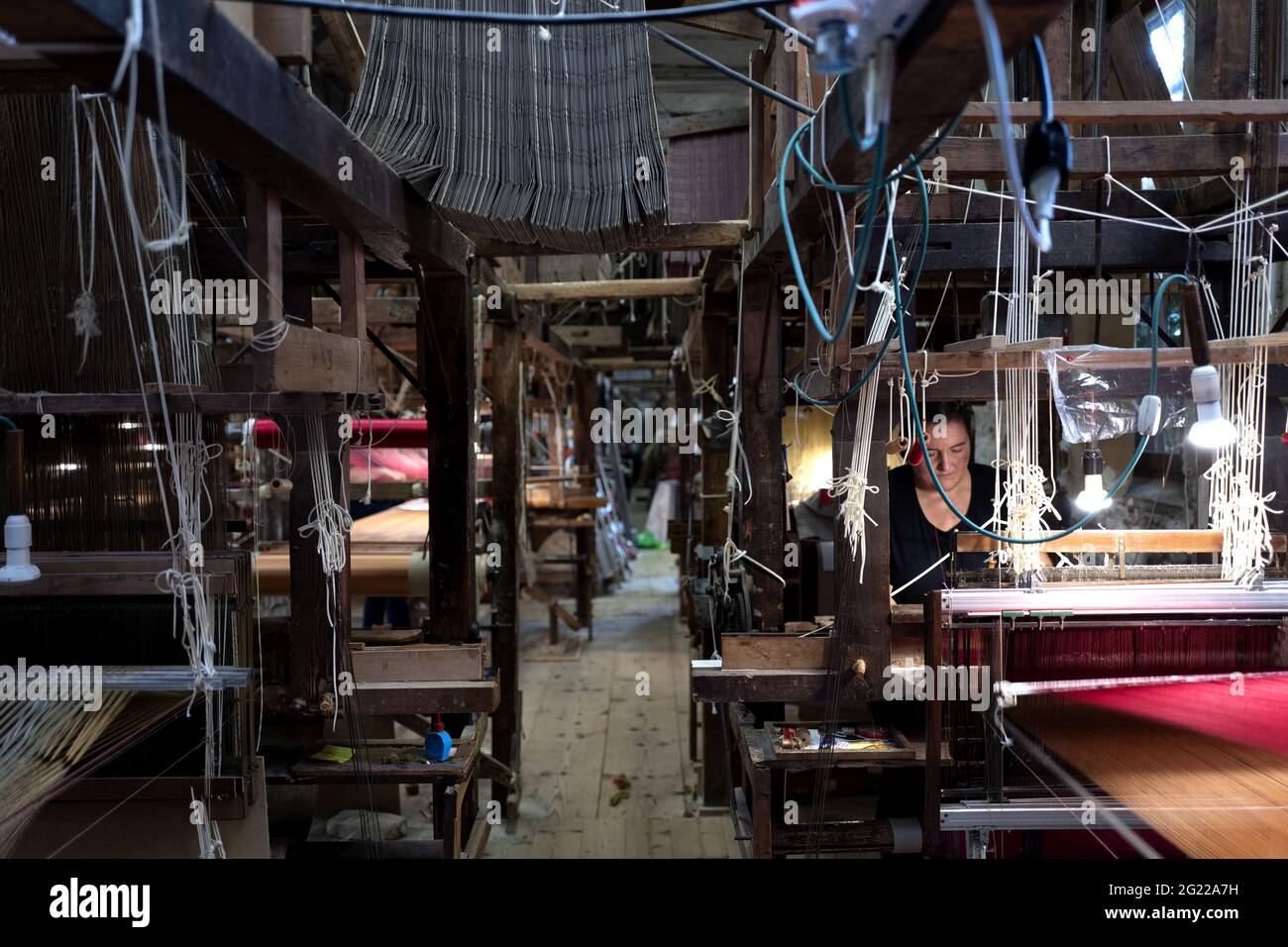 Une travailleuse au tissage fait à la main historique Luigi Bevilacqua, ils produisent des tissus fins pour le mobilier et la haute mode, à Venise, en Italie Banque D'Images