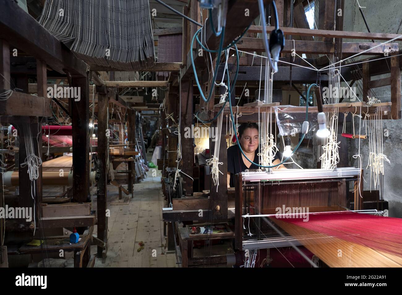Une travailleuse au tissage fait à la main historique Luigi Bevilacqua, ils produisent des tissus fins pour le mobilier et la haute mode, à Venise, en Italie Banque D'Images