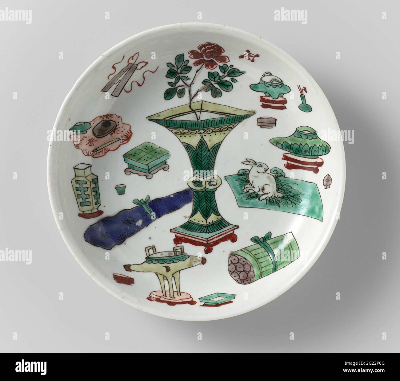 Soucoupe-plat avec objets précieux et antiquités. Plat avec paroi ronde en porcelaine, peint en bleu sous-glaçure et sur le bleu, rouge, vert, jaune, aubergine et noir. Sur les plats chinois antiquités; le fond avec quatre objets de valeur. Marqué sur le dessous avec la marque de quatre caractères de l'empereur Xuande dans un double cercle. Écaillage dans le bord ; trois fissures dans le bord. Famille verte. Banque D'Images