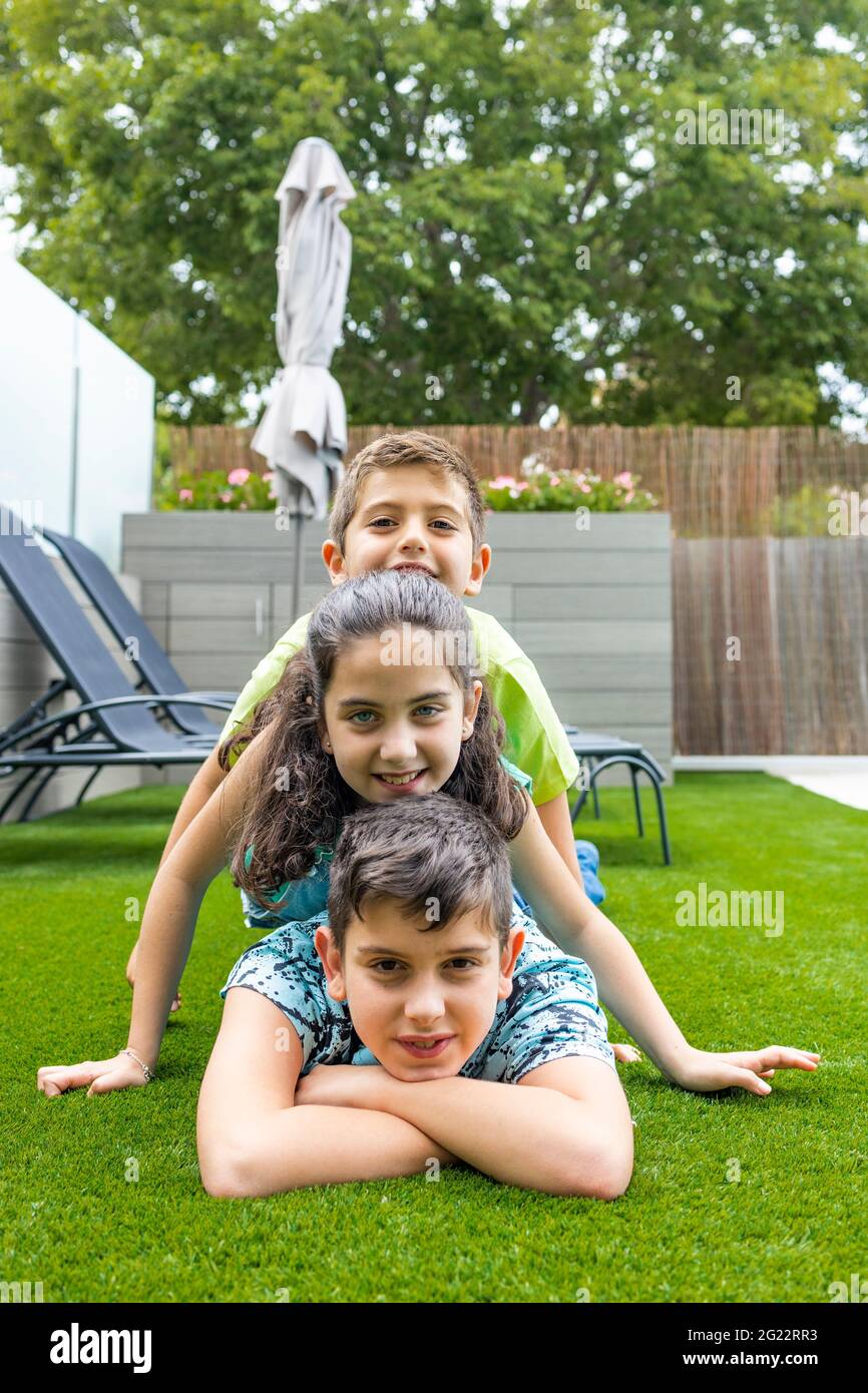 Portrait de trois enfants allongé sur une herbe Banque D'Images