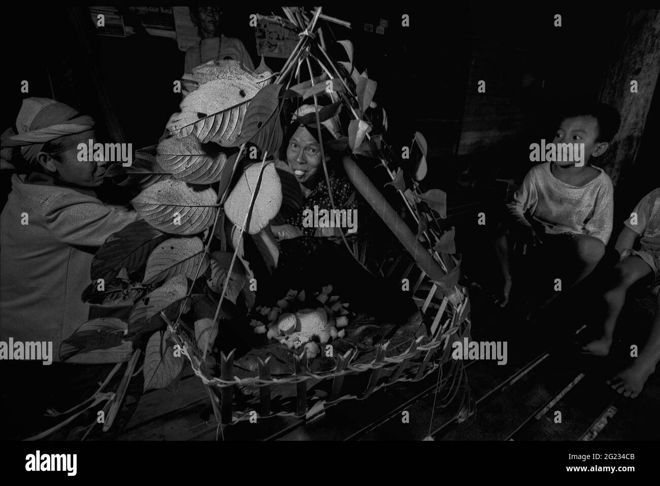 Sungai Uluk Palin, Kapuas Hulu, Kalimantan occidental, Indonésie. Mars 2007. Femmes préparant une offre alimentaire à la maison de la communauté Dayak Tamambaloh.--photographiées sur film noir et blanc, scannées, digitalisées. Banque D'Images