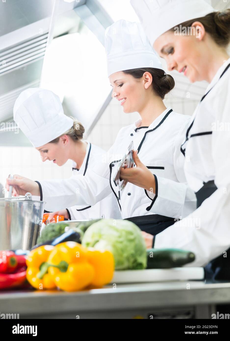 Équipe de cuisiniers de préparer des aliments en cuisine de cantine Banque D'Images