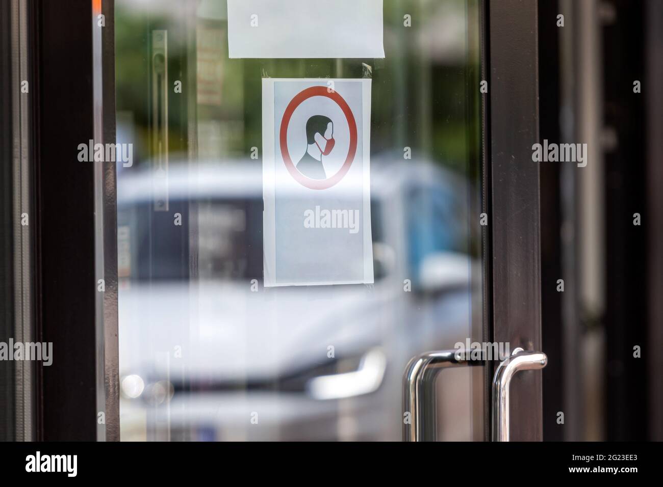 obligation de porter un masque avant d'entrer dans un bâtiment sur une porte vitrée à l'entrée Banque D'Images