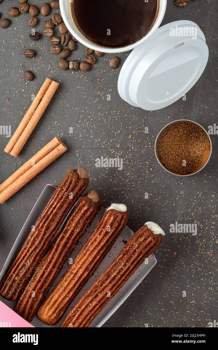 Vue de dessus du café à emporter à côté de churros de chocolat et de plaine. Banque D'Images