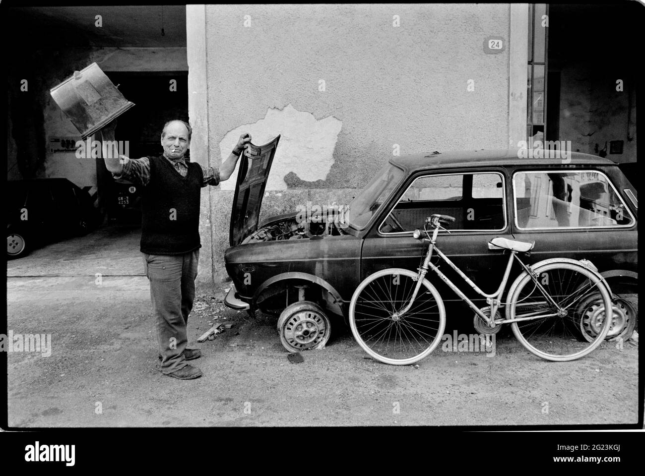 Casole d'Elsa, Toscane, Italie. 1990. Numérisé en 2019 street cafe bar et la vie dans le petit village perché de Casole d'Elsa en Toscane Italie. Homme neading avec car une certaine attention. Banque D'Images