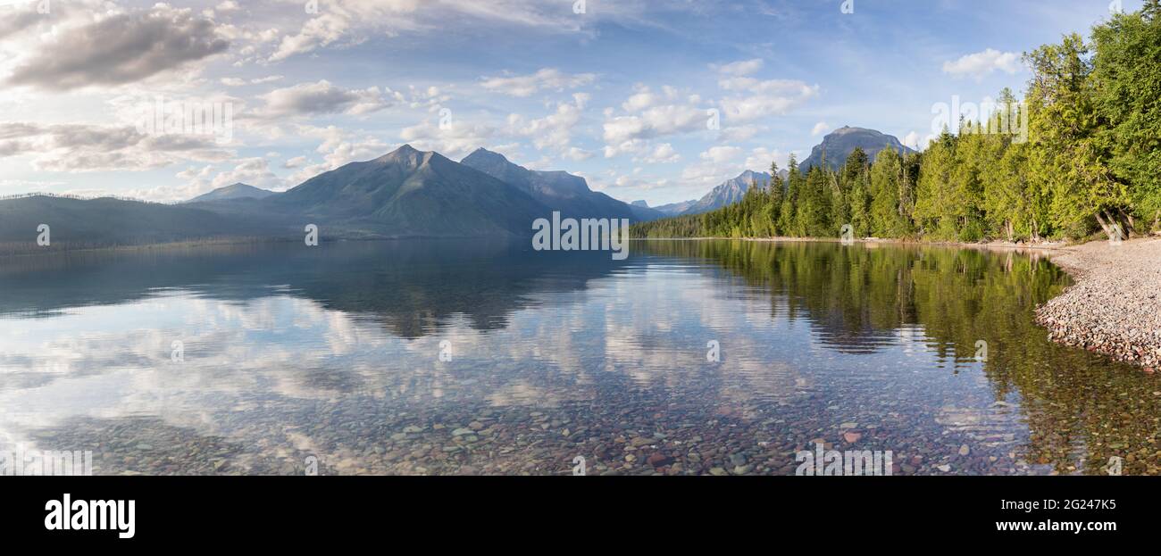Belles montagnes se reflétant dans le lac McDonald avec des galets en premier plan. Parc national des Glaciers, Montana Banque D'Images
