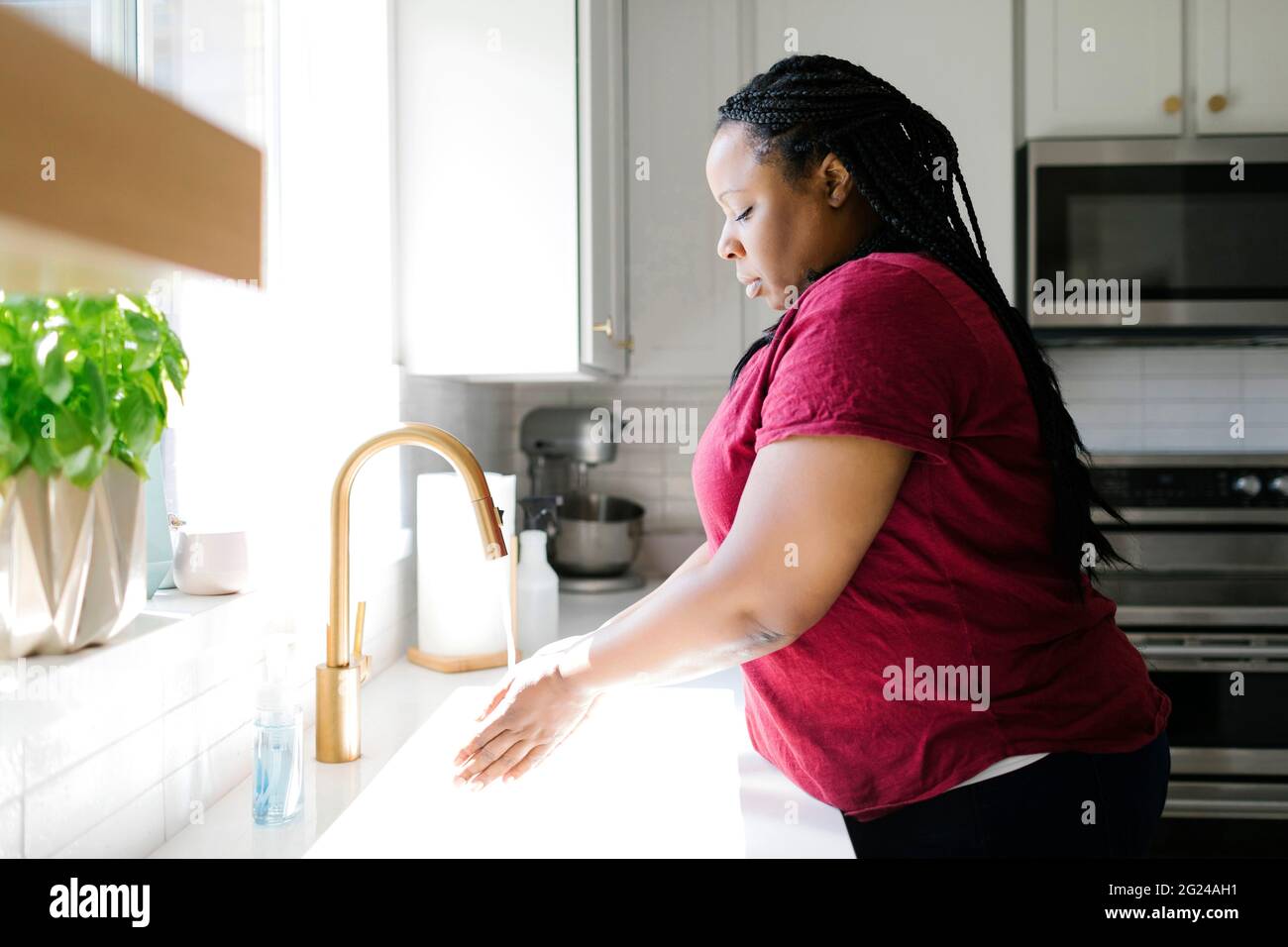 Woman in kitchen sink Banque D'Images