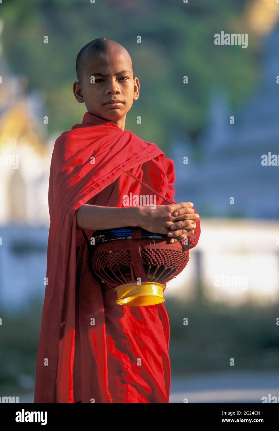 Myanmar, Mandalay, moine bouddhiste tenant des bols pendant les almes du matin Banque D'Images