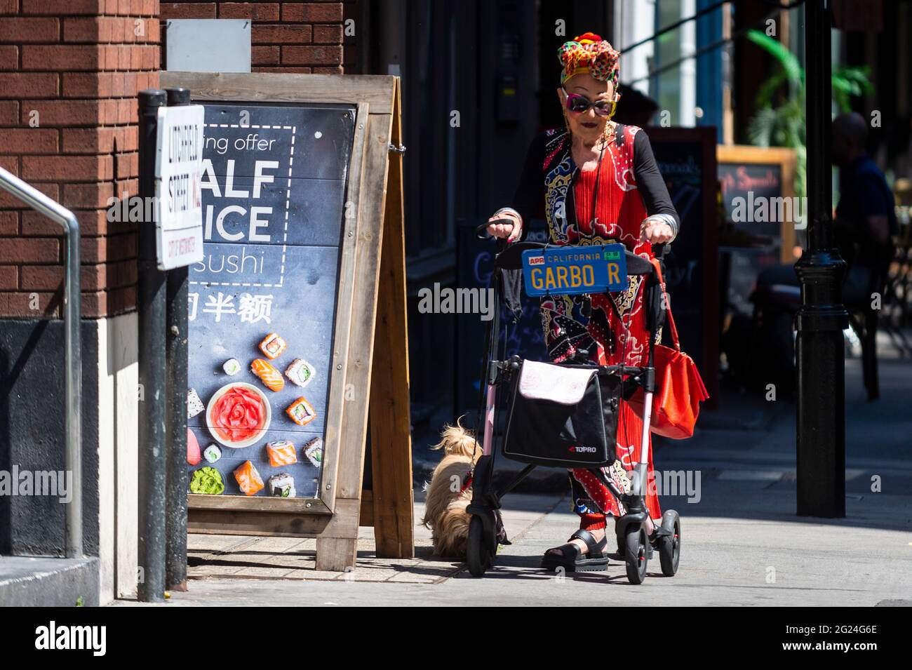 Londres, Royaume-Uni. 8 juin 2021. Météo au Royaume-Uni - une femme élégamment habillée marche son chien près de Cambridge Circus lors d'un après-midi chaud et ensoleillé, lorsque les températures ont augmenté à 25 °C dans la capitale. Credit: Stephen Chung / Alamy Live News Banque D'Images