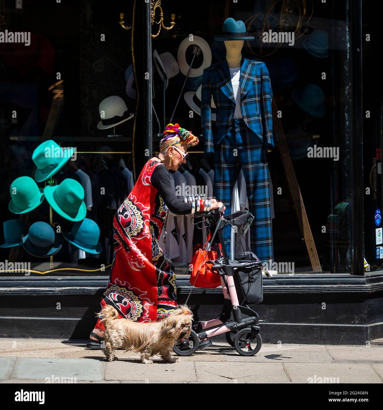 Londres, Royaume-Uni. 8 juin 2021. Météo au Royaume-Uni - une femme élégamment habillée marche son chien en passant par un magasin de chapeau près de Cambridge Circus lors d'un après-midi chaud et ensoleillé, quand les températures ont augmenté à 25 °C dans la capitale. Credit: Stephen Chung / Alamy Live News Banque D'Images