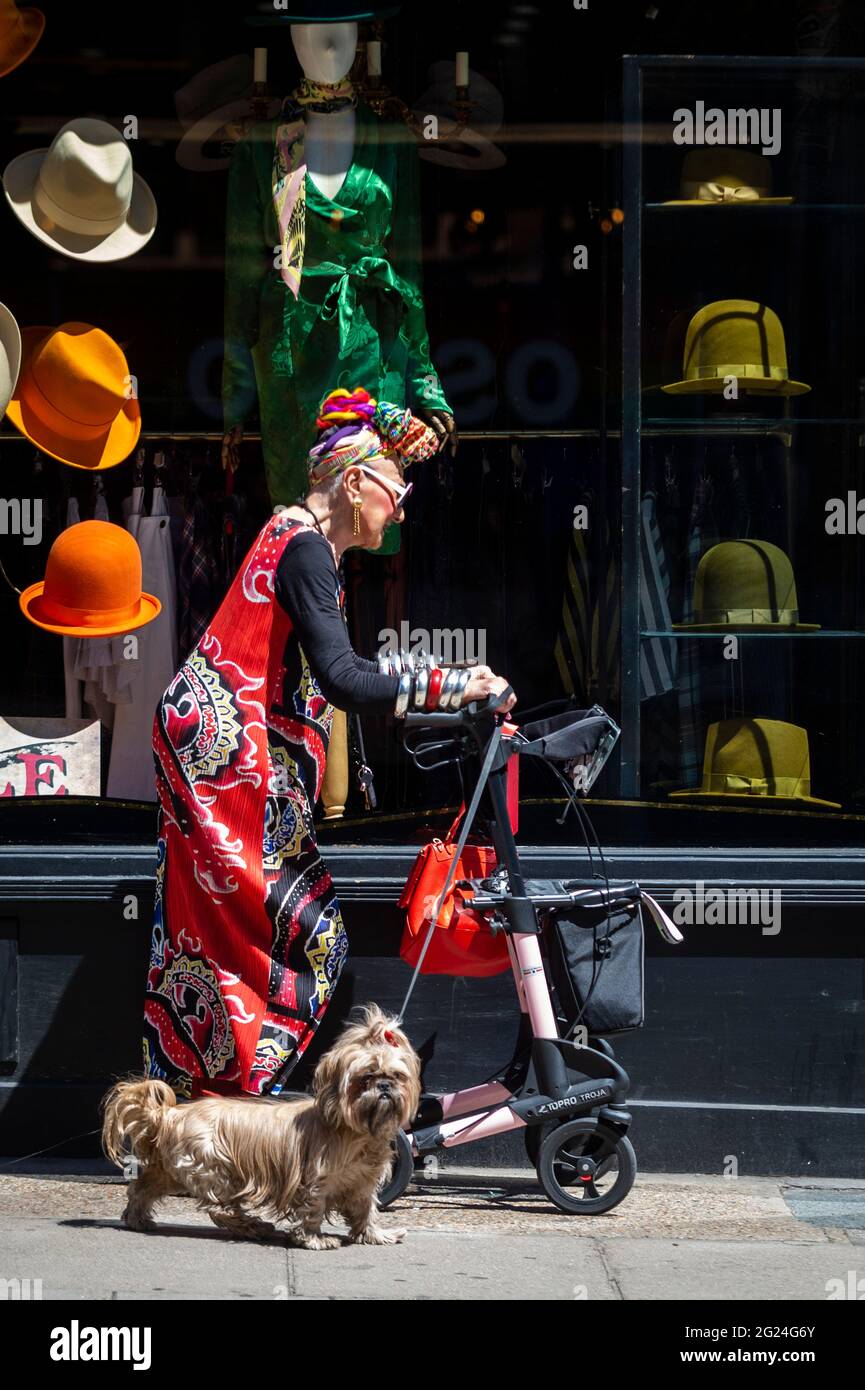 Londres, Royaume-Uni. 8 juin 2021. Météo au Royaume-Uni - une femme élégamment habillée marche son chien en passant par un magasin de chapeau près de Cambridge Circus lors d'un après-midi chaud et ensoleillé, quand les températures ont augmenté à 25 °C dans la capitale. Credit: Stephen Chung / Alamy Live News Banque D'Images