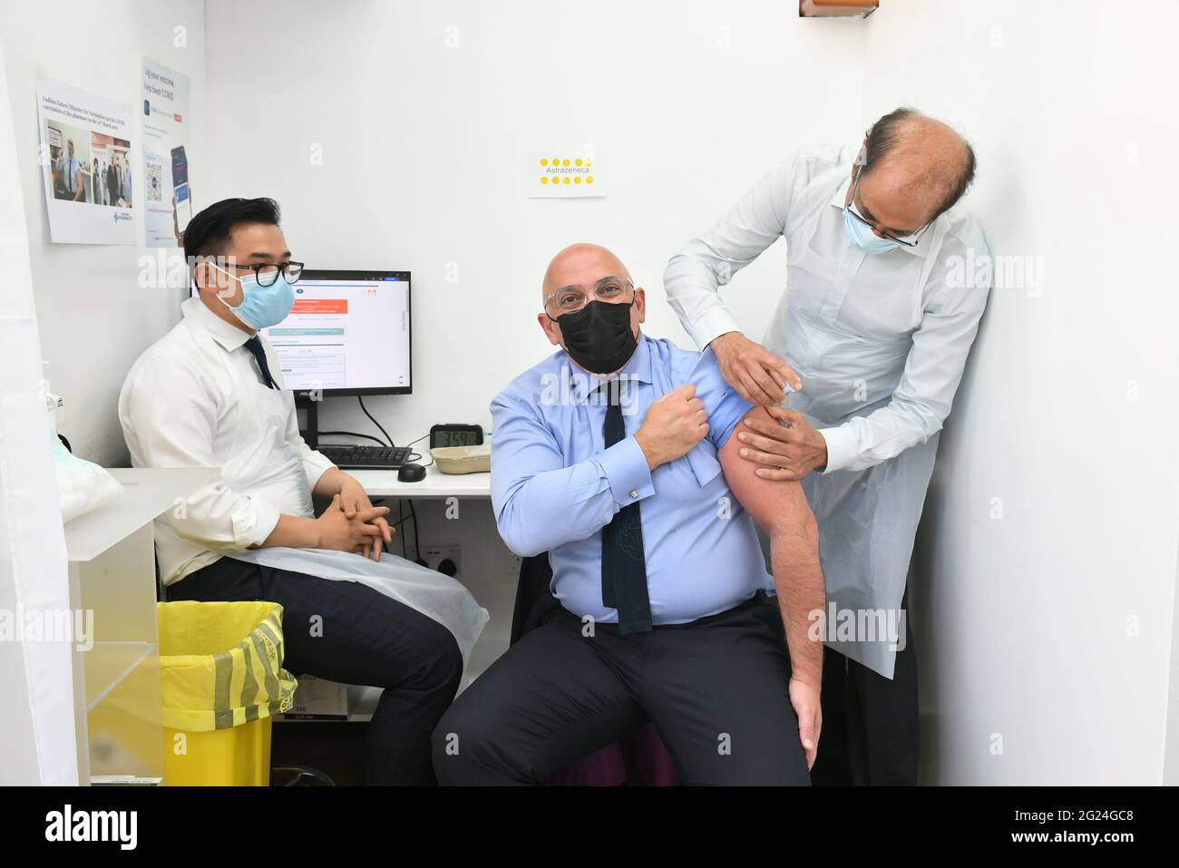 Nadhim Zahawi, ministre du déploiement du vaccin Covid, avec les pharmaciens Victor Truong (à gauche) Salim Jetha, alors qu'il reçoit sa deuxième dose de la vaccination COVID-19 à la pharmacie de Lewisham Grove, dans le sud-est de Londres. Date de la photo: Mardi 8 juin 2021. Banque D'Images