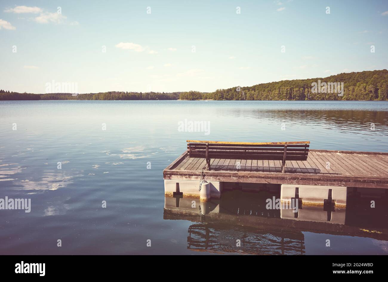 Banc sur une jetée flottante en bois, application de couleurs, lac Lipie, village de Dlugie, Pologne. Banque D'Images