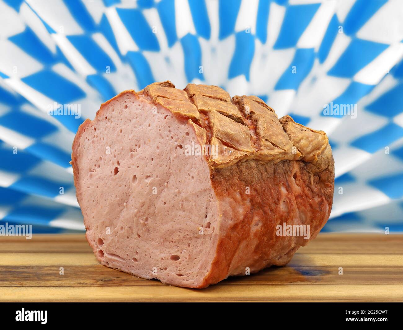 pain de viande bavarois chaud ou leberkaese sur une assiette en bois servi devant un motif typique de strass bavarois Banque D'Images