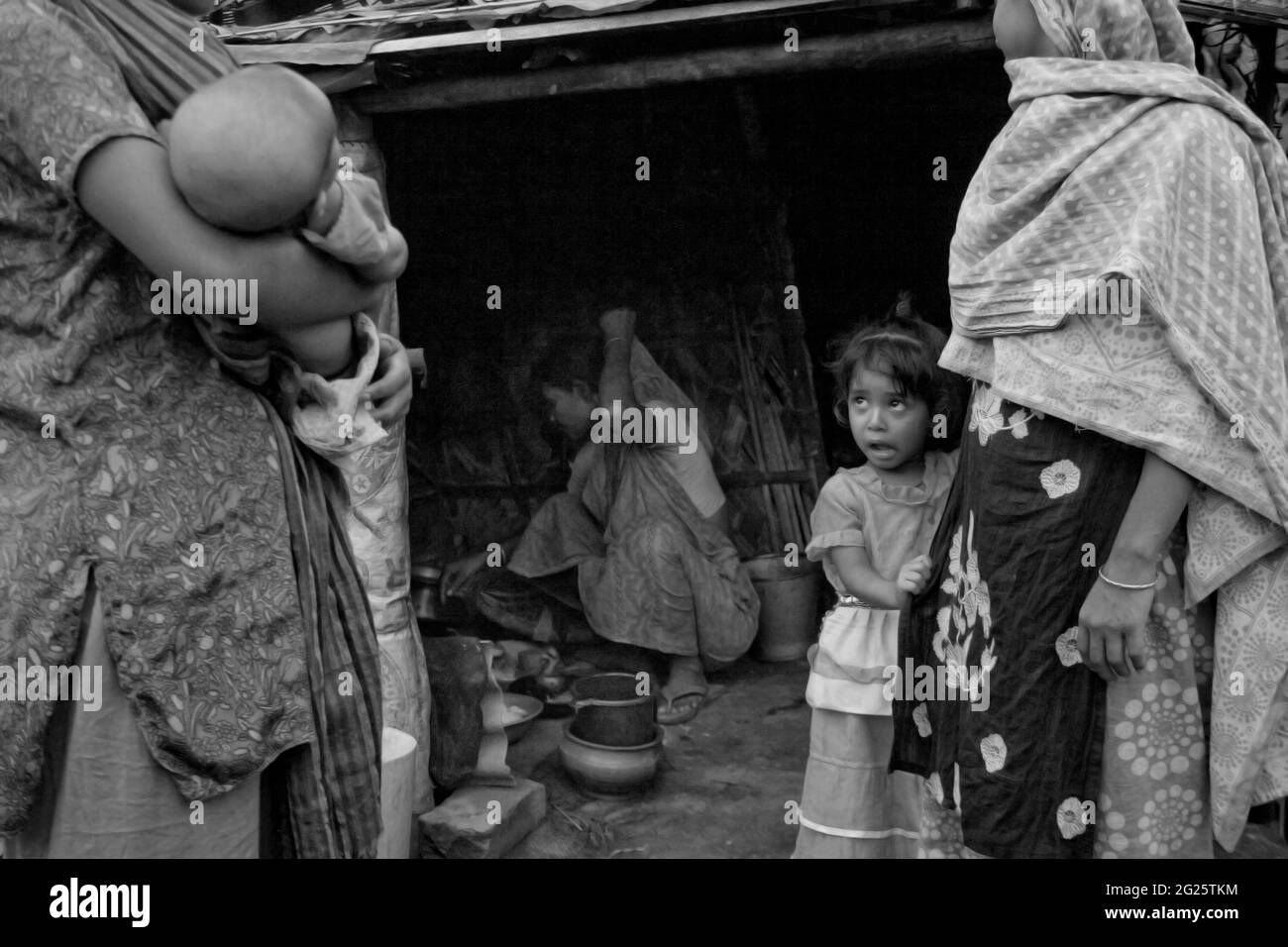 Une famille dans un bidonville dans la région de Hazaribagh dans le Vieux Dhaka. C'est l'après-midi et la femme dans la cuisine fait la cuisine tandis que d'autres passent le temps. Partie de l'histoire Gray Reality, sur Hazaribagh région dans le vieux Dhaka, par Saikat Ranjan Bhadra. Hazaribagh, Dhaka, Bangladesh. 25 mai 2009. Banque D'Images Une famille dans un bidonville dans la région de Hazaribagh dans le Vieux Dhaka. C'est l'après-midi et la femme dans la cuisine fait la cuisine tandis que d'autres passent le temps. Partie de l'histoire Gray Reality, sur Hazaribagh région dans le vieux Dhaka, par Saikat Ranjan Bhadra. Hazaribagh, Dhaka, Bangladesh. 25 mai 2009. Banque D'Images
