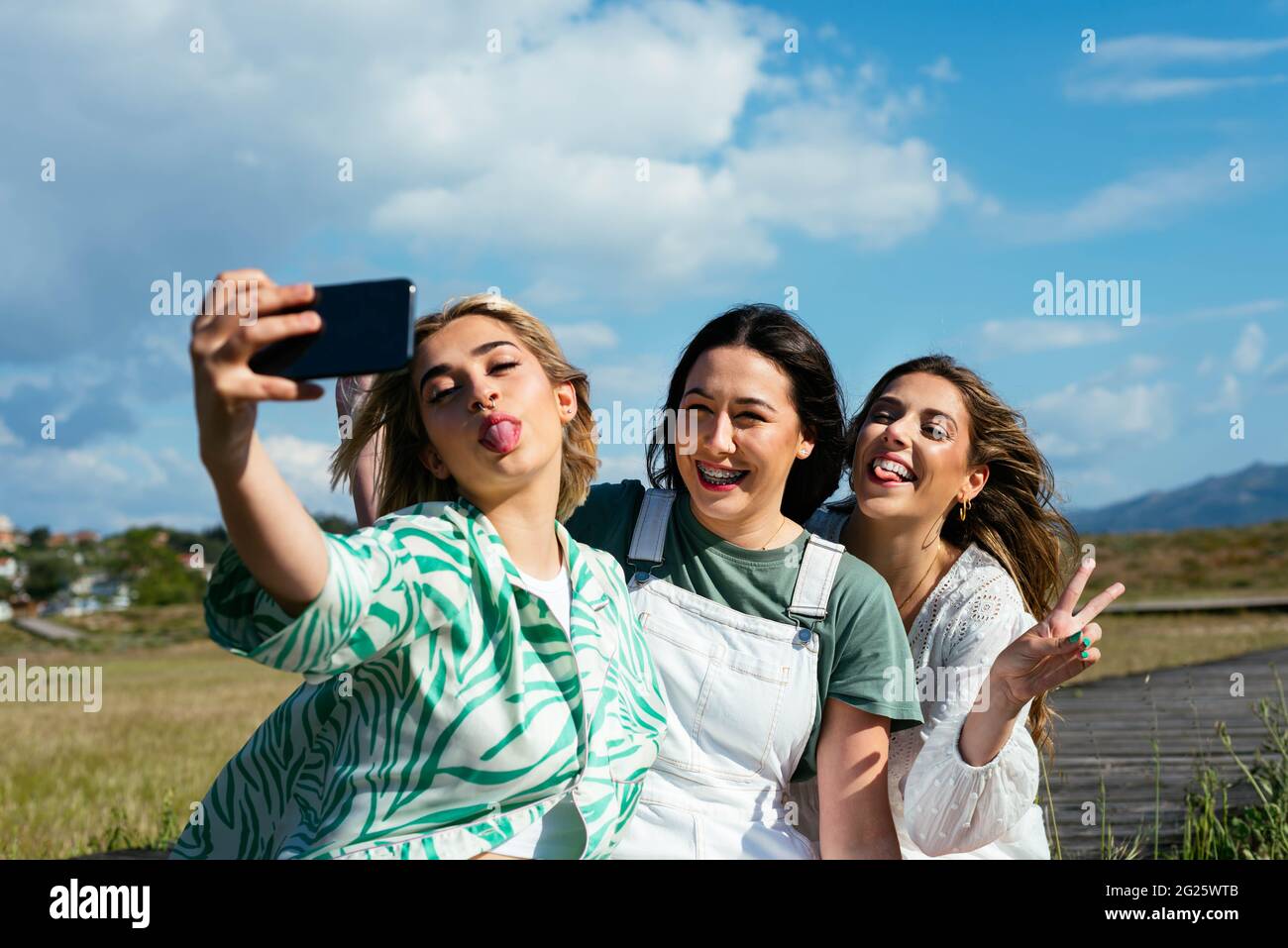 Des filles souriantes qui prennent un selfie ensemble à l'extérieur Banque D'Images