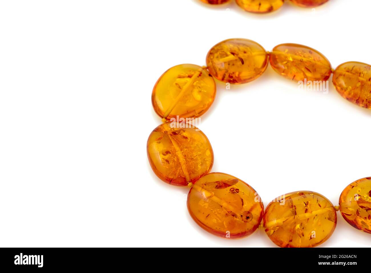 collier composé de perles orange de luxe au miel transparent et poli naturel avec inclusions sur blanc. Gros plan sélectif de la mise au point douce. Espace pour le texte Banque D'Images