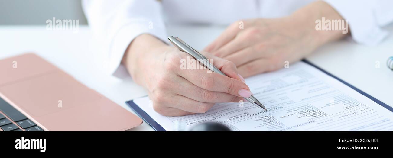 Médecin remplissant les antécédents médicaux des patients en clinique de près Banque D'Images