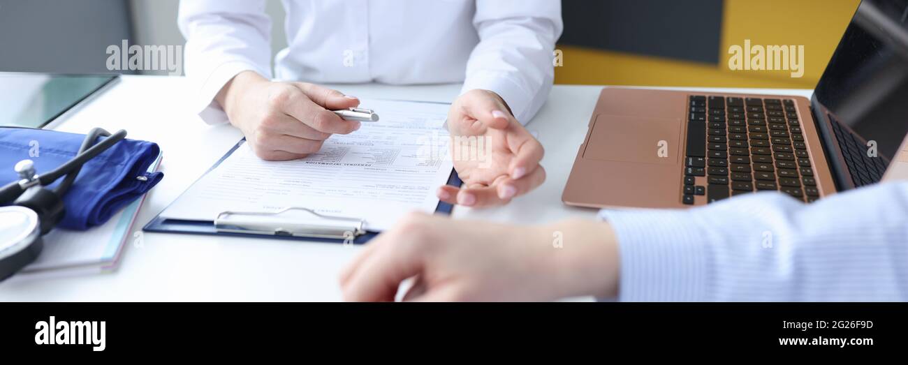 Médecin à l'écoute des plaintes des patients dans le bureau fermé Banque D'Images