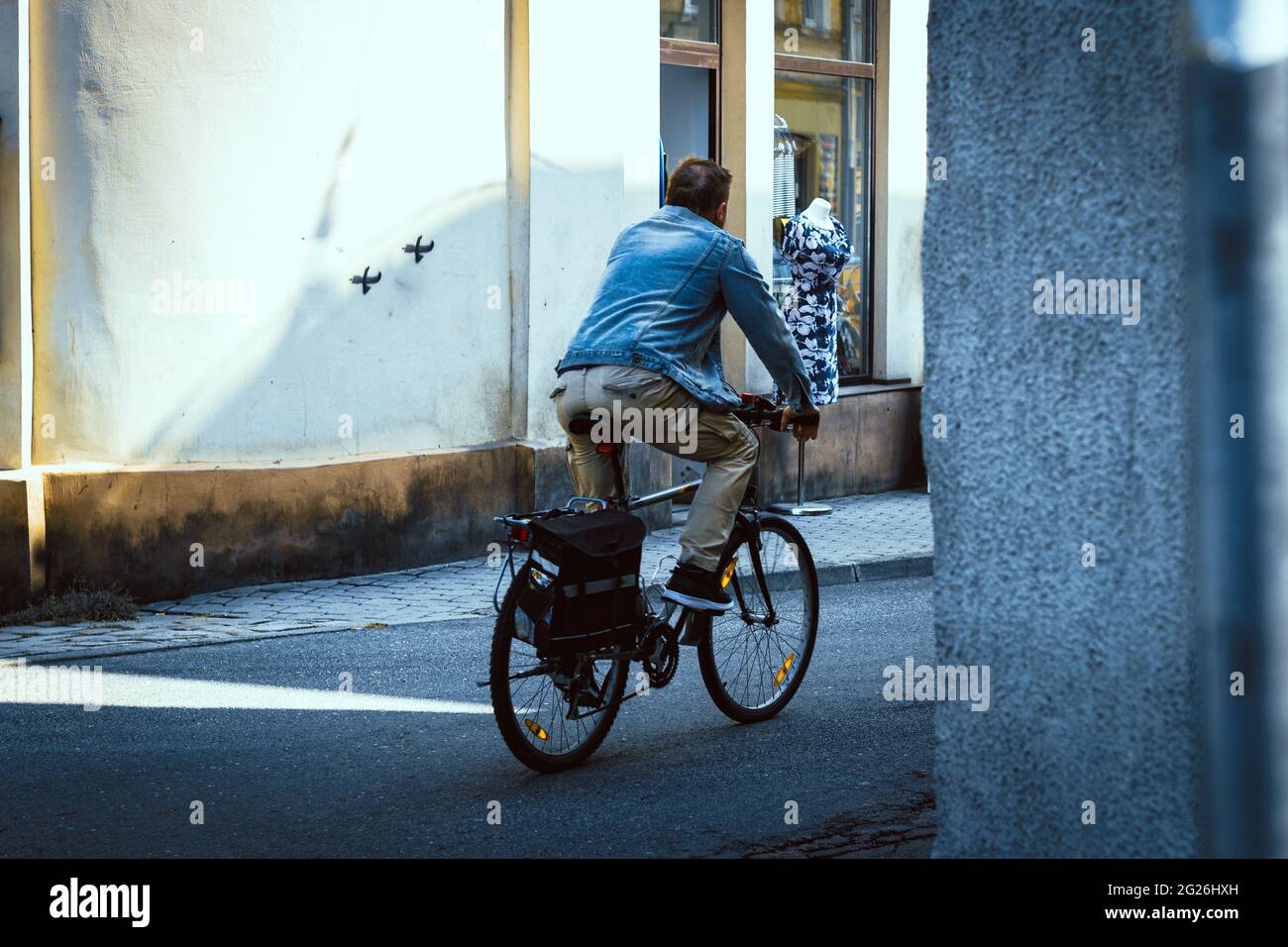homme à vélo à côté d'un magasin de vêtements Banque D'Images