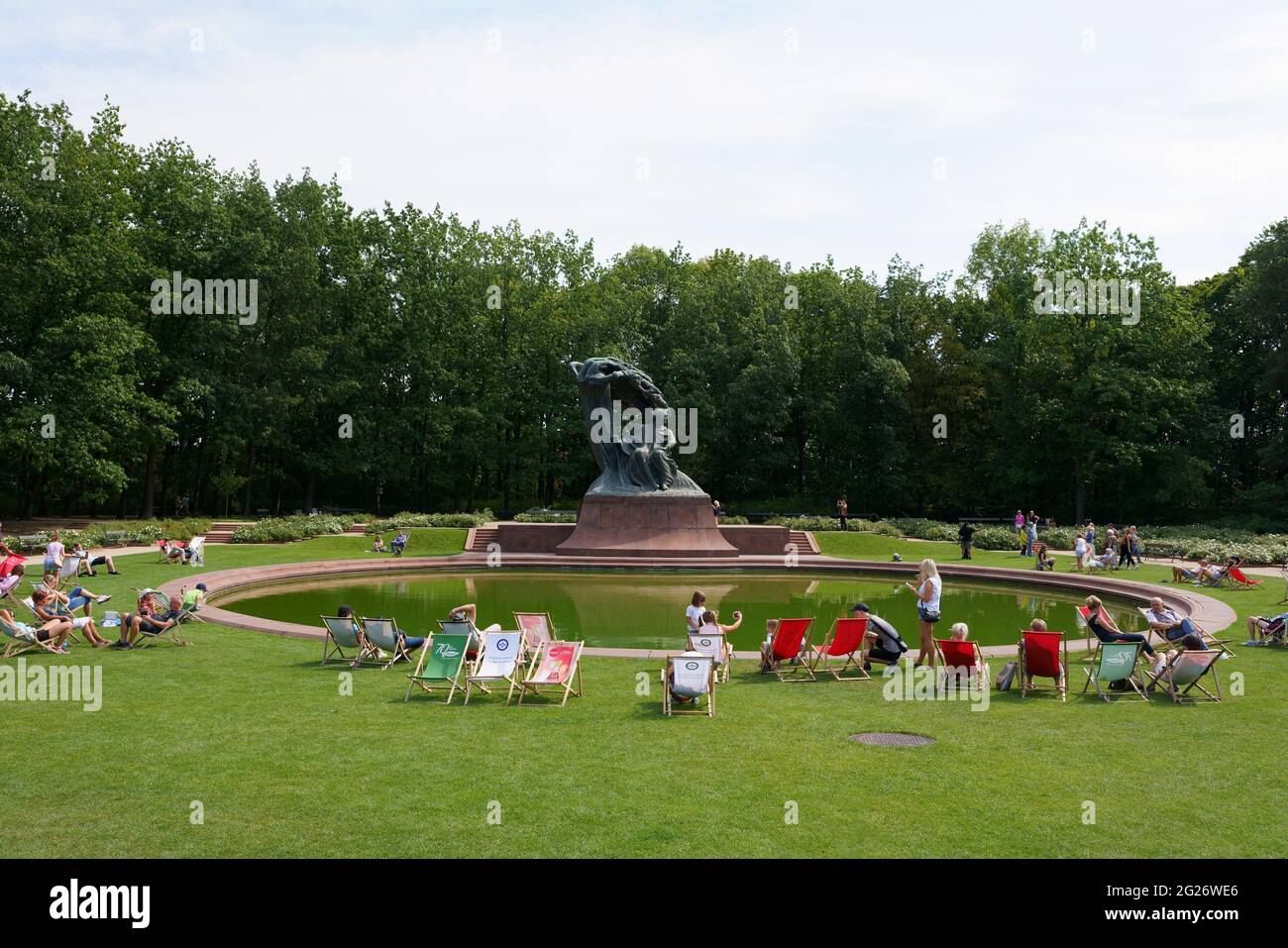 Les gens se reposent sur des chaises longues en face du monument Chopin dans le parc royal Lazienki à Varsovie, en Pologne Banque D'Images