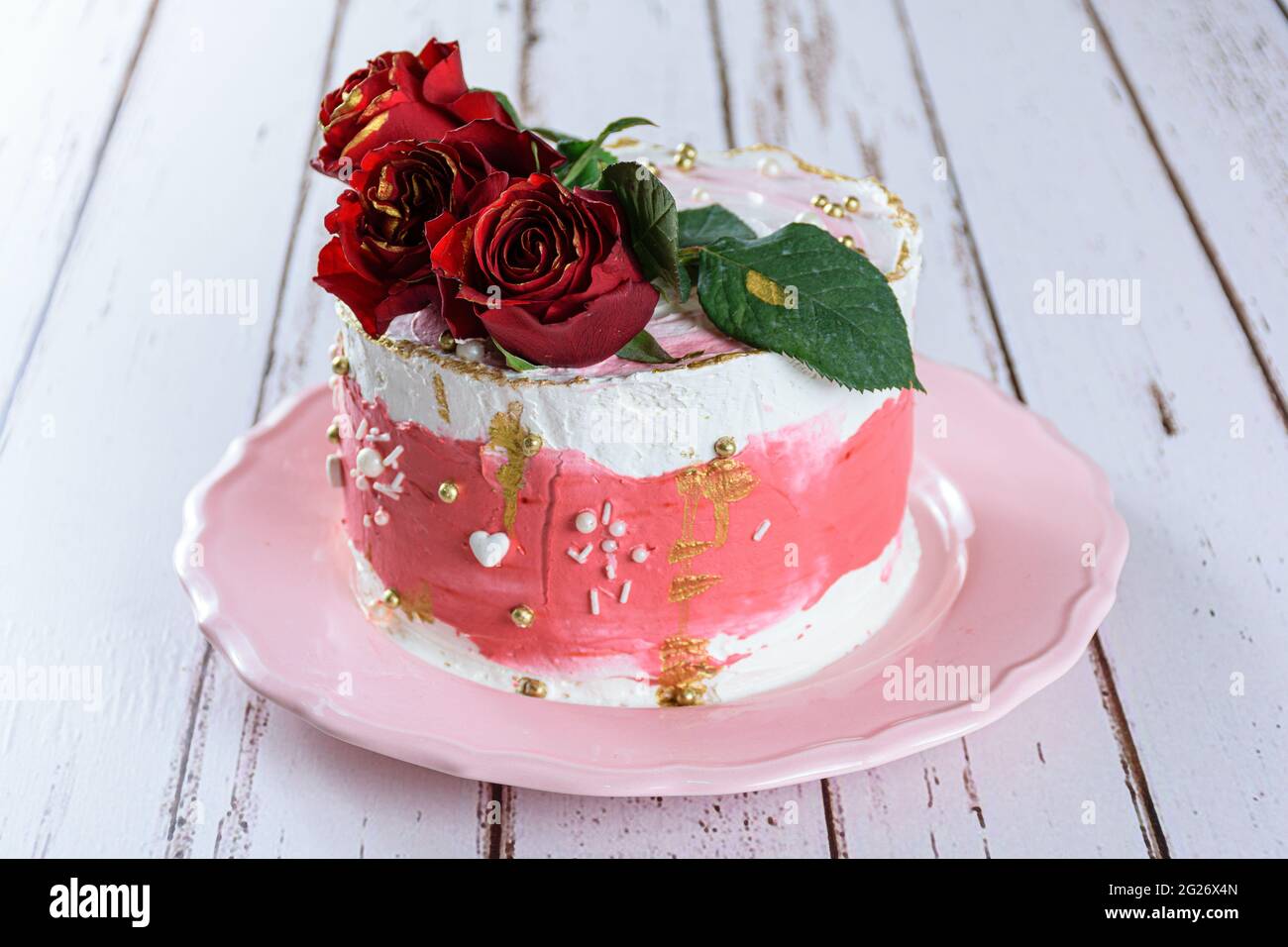 Gateau Au Chocolat Recouvert De Creme De Beurre Suisse Meringue Avec Trois Fleurs Rouges Sur Le Dessus Sur Une Assiette Rose Photo Stock Alamy