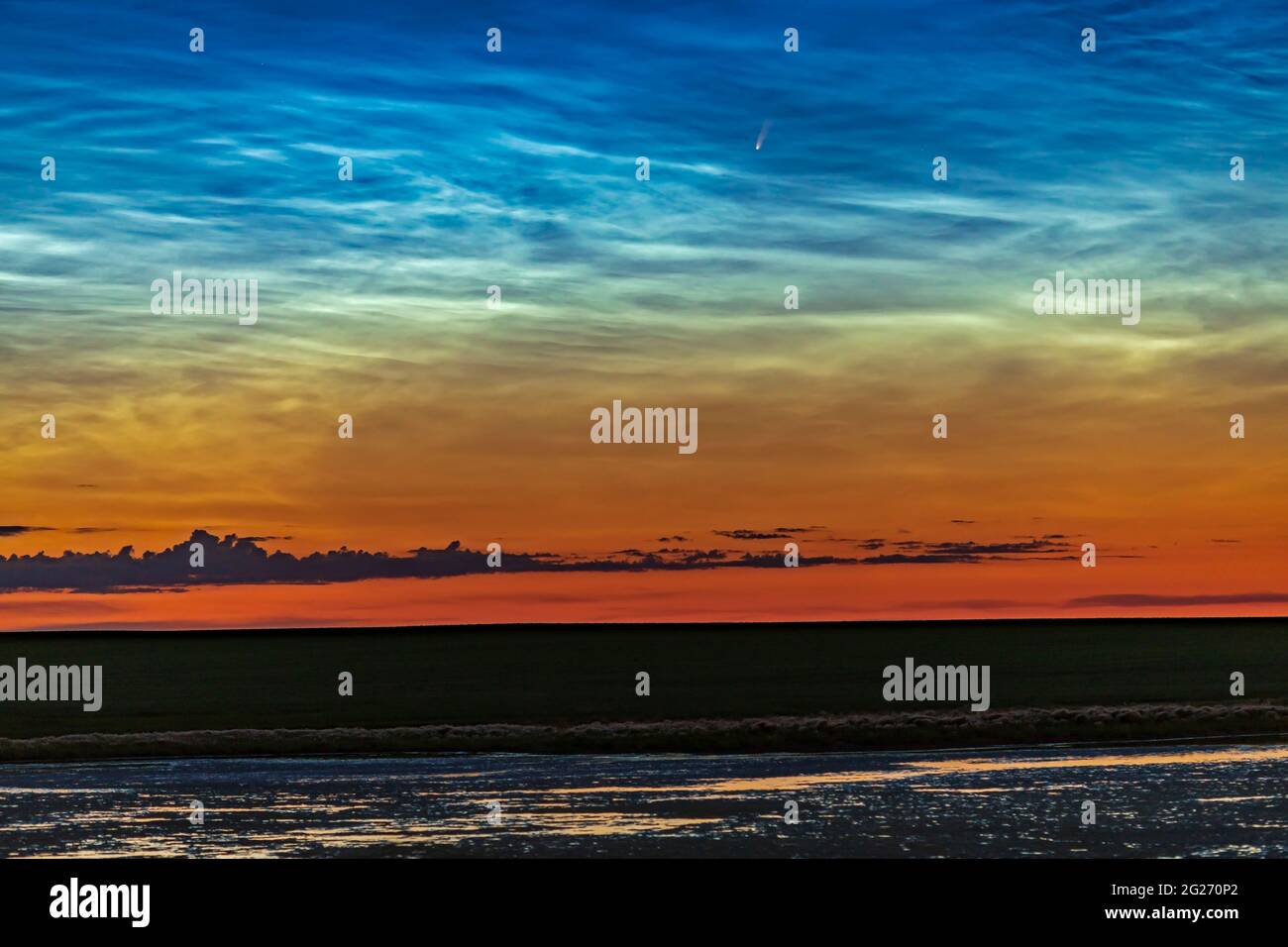 Comet NEOWISE et nuages nocturnes au-dessus d'un étang en Alberta, Canada. Banque D'Images