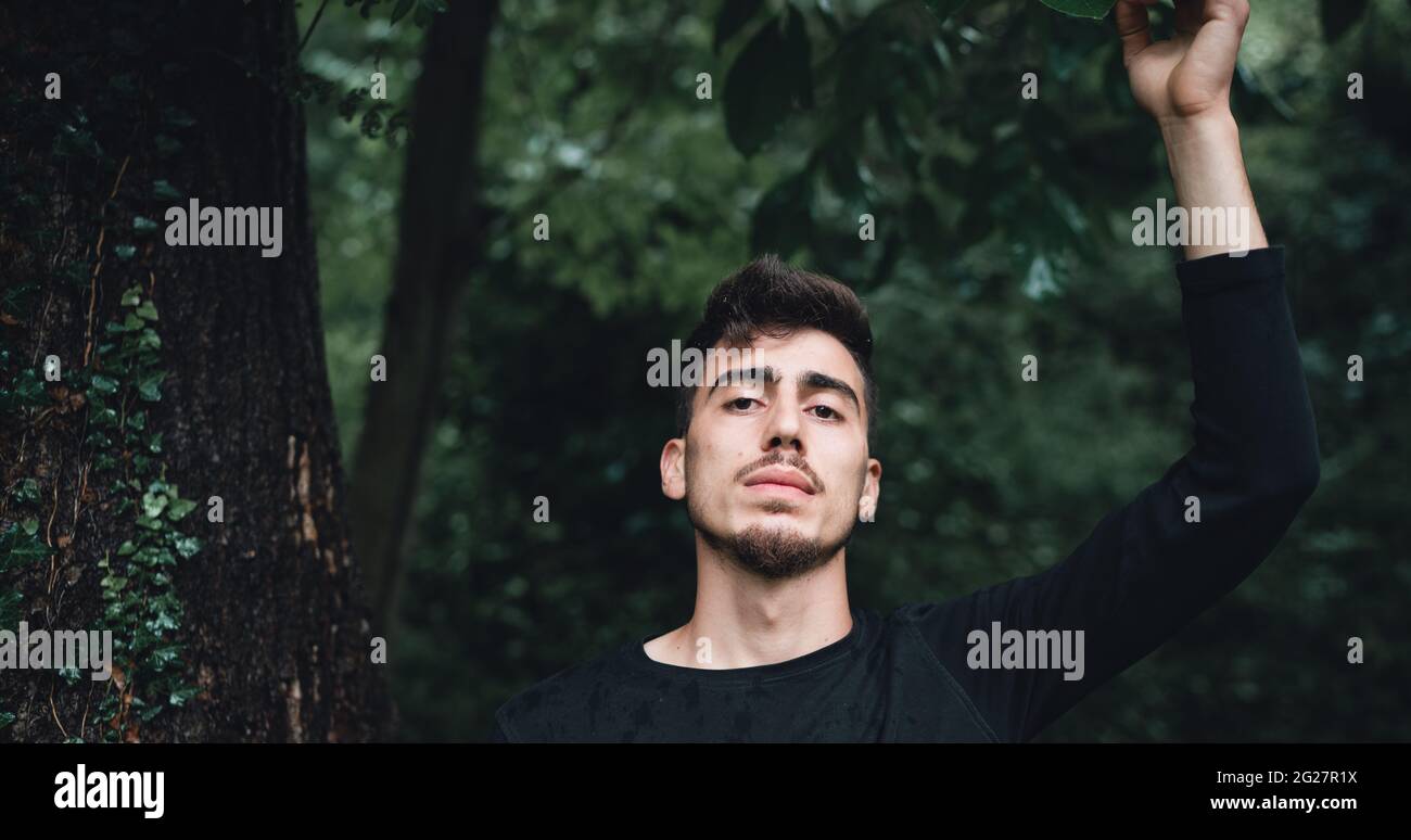 Beau jeune homme se mouille et pose dans la forêt Banque D'Images