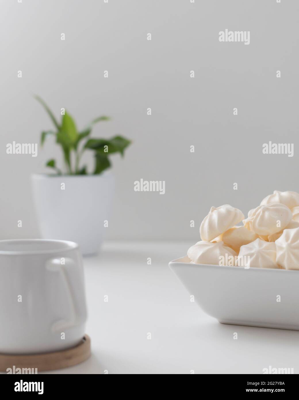 dans un bol, faire la crème de meringues avec une tasse sur fond blanc Banque D'Images