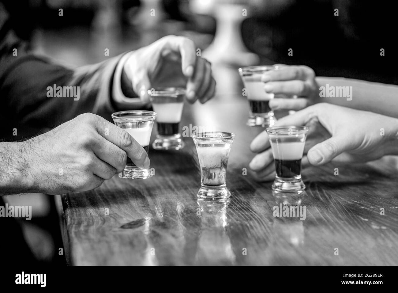 Les amis boivent une dose ou une liqueur. Cinq verres d'alcool. Cocktail à la discothèque. Groupe d'amis tequila shot verres au bar. Mains mâles lunettes de Banque D'Images