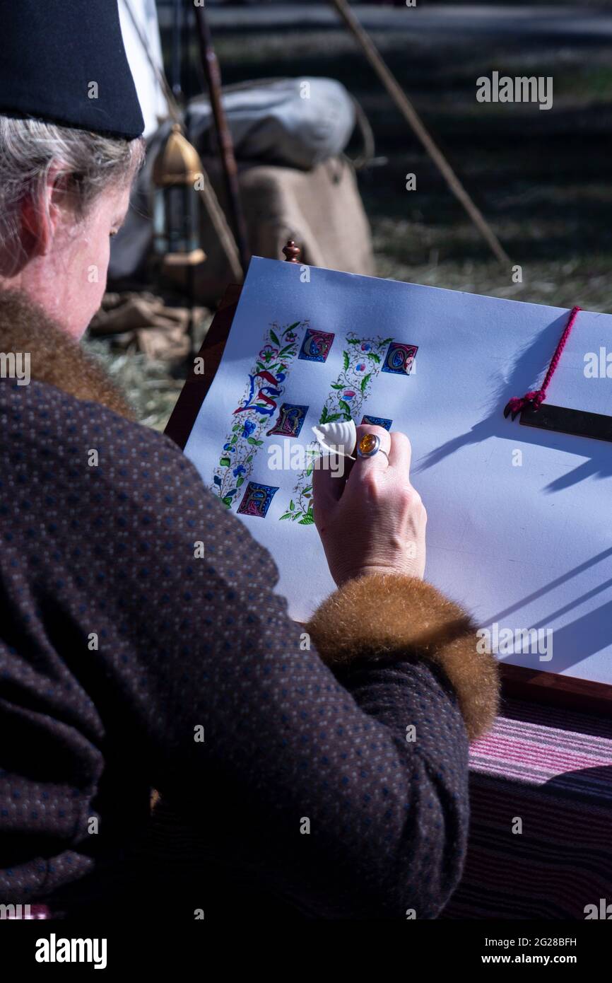 Un artiste utilisant un Quill de plumes démontrant comment dessiner des lettres illuminées au Abby Medieval Festival, Caboolture, Queensland, Australie. Banque D'Images