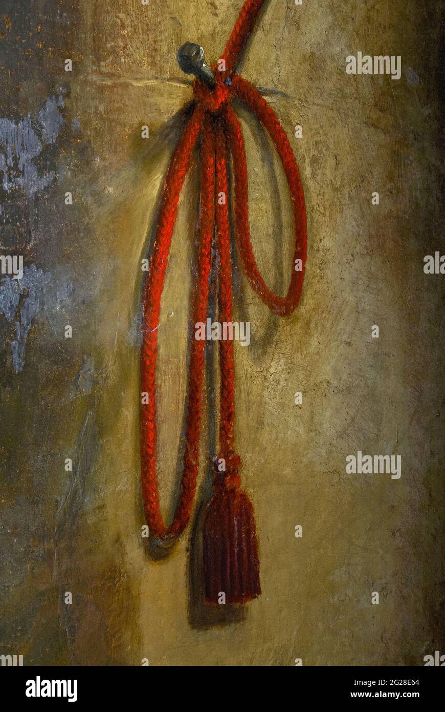 Cette corde ou corde rouge tasselée, apparemment enroulée autour d'un clou fait main dans un mur ocre, est un détail d'une œuvre illusoire du XVIIe siècle à l'intérieur de l'Hôtel de Châteaurenard à Aix-en-Provence, Bouches-du-Rhône, Provence-Alpes-Côte d'Azur, France. À l'autre extrémité de la corde, un perroquet vert dans une cage rouge et bleue semble pendre d'un balcon peint par l'artiste de la Cour d'origine bruxelloise Jean Daret (1613-1668). Il a décoré l'intérieur de la maison dans la rue Gaston de Saporta en 1654, six ans avant que la maison ne devienne la demeure temporaire de Louis XIV Banque D'Images