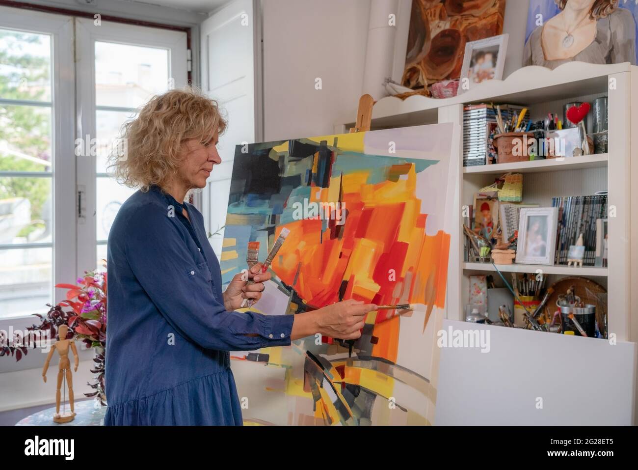 Femme artiste de dessins, se préparant à créer une image de peinture abstraite. Dans l'atelier de la galerie. Banque D'Images