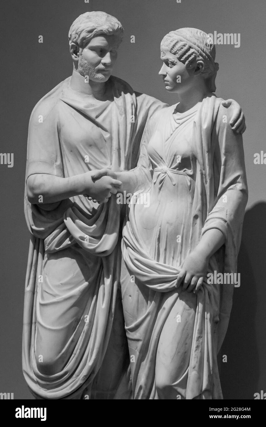 Photo en noir et blanc d'anciennes statues romaines d'un couple mature tenant les mains Banque D'Images