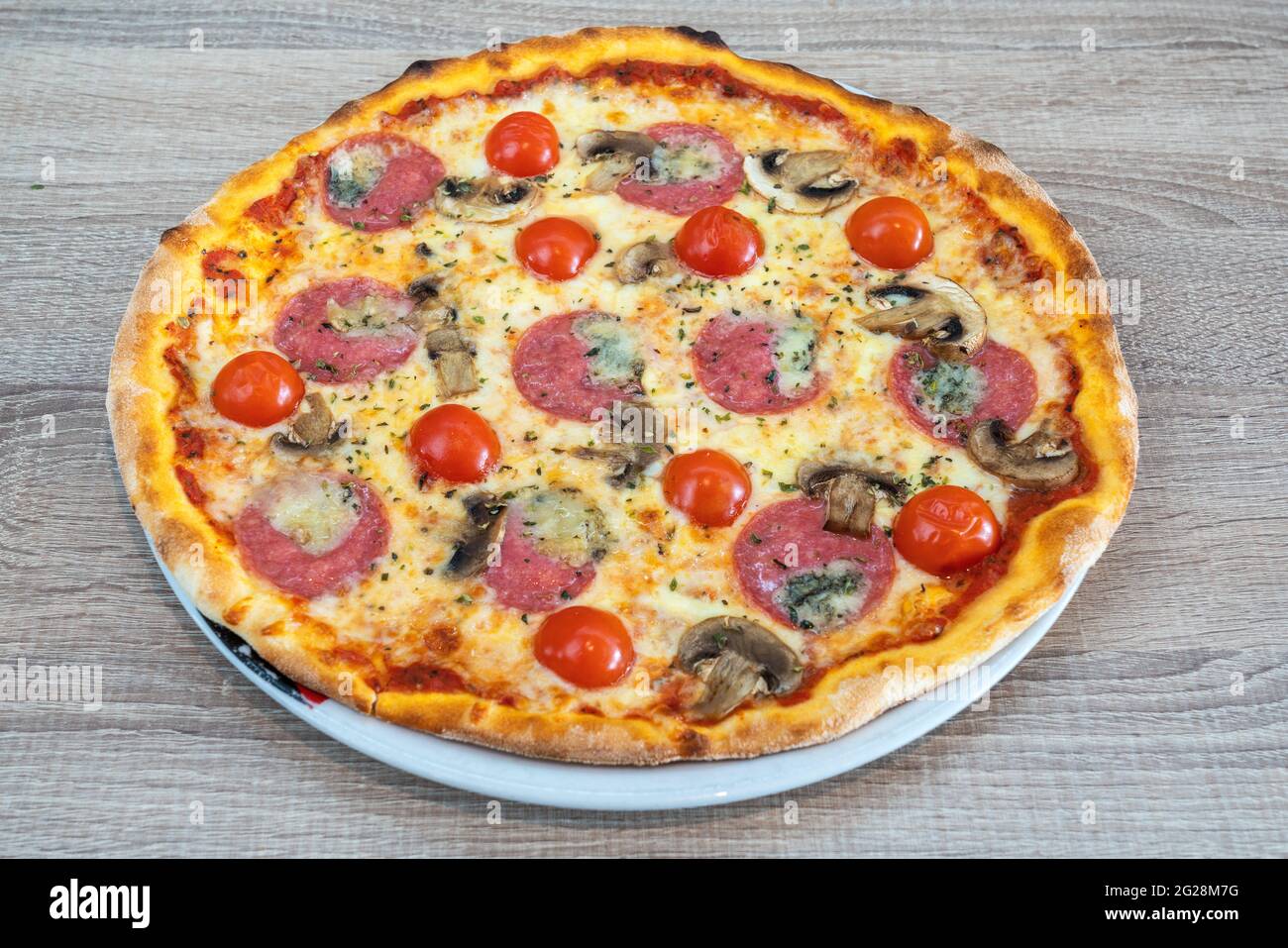 Délicieuse pizza italienne traditionnelle à la mozzarella. De tomates, salami et champignons. Dans une plaque, gros plan par le dessus. Banque D'Images