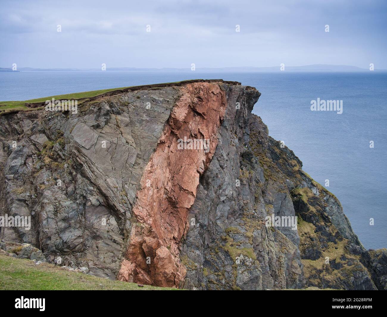Mélanges frappants de différents types de roches grises et rouges dans les falaises côtières de la Ness de Hillswick dans Northmavine, Mainland, Shetland, Royaume-Uni Banque D'Images