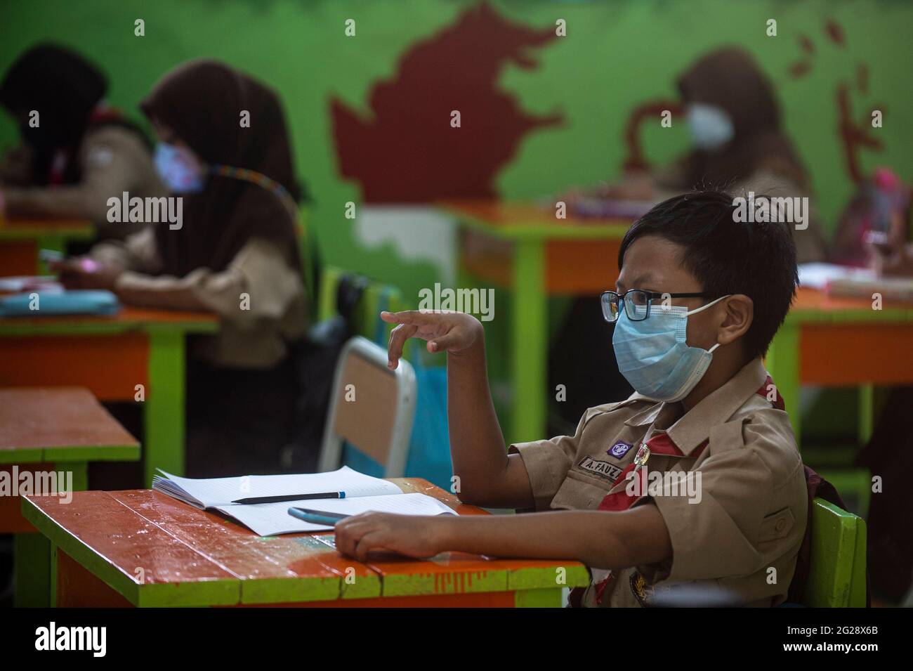 Jakarta, Indonésie. 9 juin 2021. Un élève élémentaire portant un masque facial est vu dans une salle de classe au cours d'une activité d'apprentissage face-à-face d'essai dans le cadre de l'épidémie de COVID-19 dans une école de Jakarta, Indonésie, le 9 juin 2021. Credit: Agung Kuncahya B./Xinhua/Alay Live News Banque D'Images