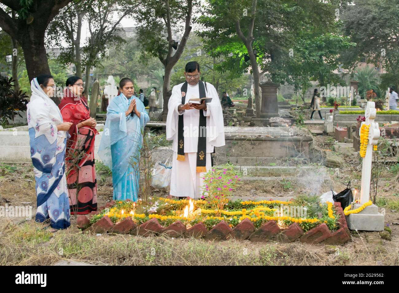 KOLKATA, BENGALE-OCCIDENTAL , INDE - 2 NOVEMBRE 2014 : prêtre et parents à la journée "All Souls day" souvenir à l'ancien cimetière de South Park Street, Kolkata. Banque D'Images