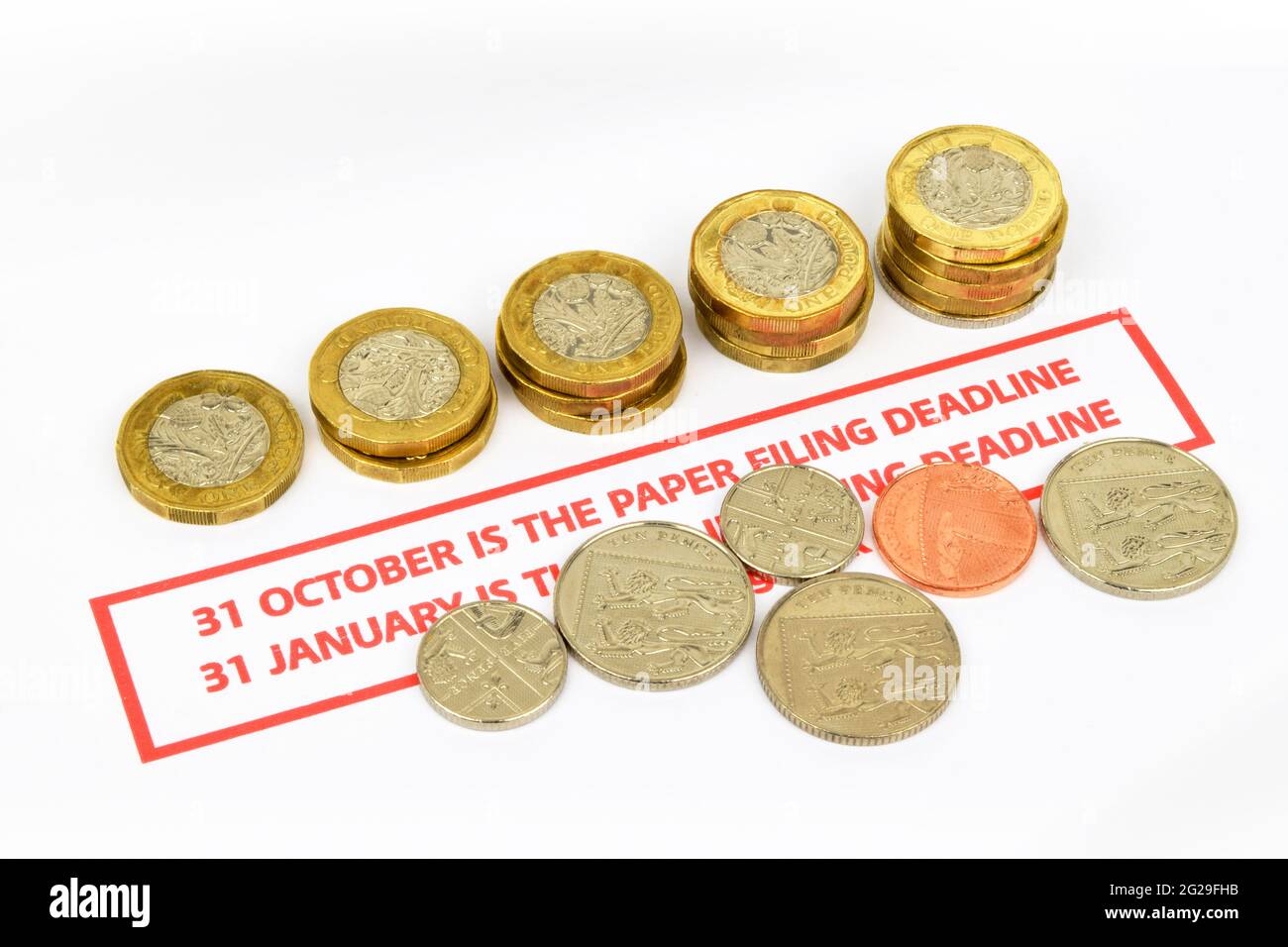 Rappel de la date limite de production du papier pour les déclarations fiscales au Royaume-Uni Une vie fixe comprenant un rappel d'échéance en rouge, des pièces de monnaie et un stylo. Banque D'Images