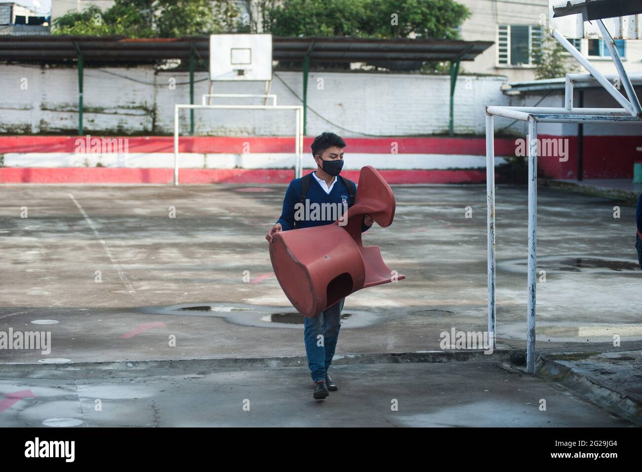 Un étudiant porte un bureau dans une salle de classe de l'École technique agricole Eduardo Salazar Gomez. L'Équateur a autorisé le retour aux classes volontaires dans les institutions privées et fiscales, c'est le cas de l'Ecole technique agricole Eduardo Salazar Gomez dans la paroisse de Pifo située dans le nord-ouest de la capitale Quito, dans cet établissement environ 43 étudiants de 1ère, La 2e année sont entrées et la 3e du baccalauréat dans chaque classe la capacité totale est de 12 étudiants en matière de distance sociale, cette initiative répond au besoin de beaucoup de ces jeunes d'être en mesure d'étudier s Banque D'Images