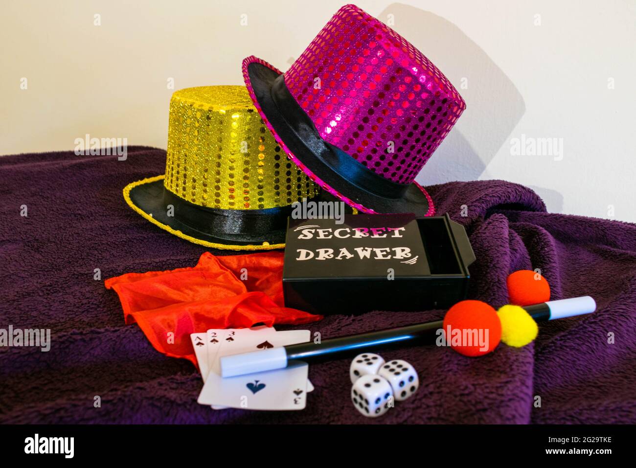 Magic show magiciens trick concept fond. Boîte magique pour enfants avec chapeaux à paillettes, baguette magique, cartes à jouer, tour de coupe et de balle, tirage secret Banque D'Images