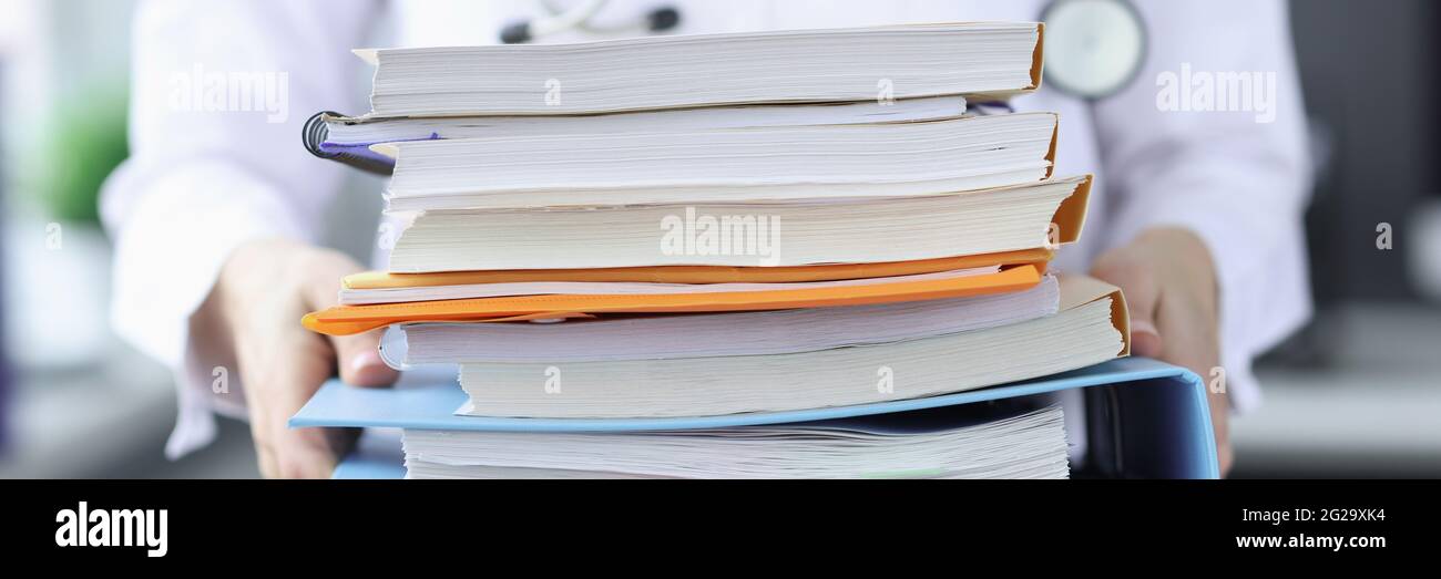 Le médecin tient une grande pile de dossiers Banque D'Images