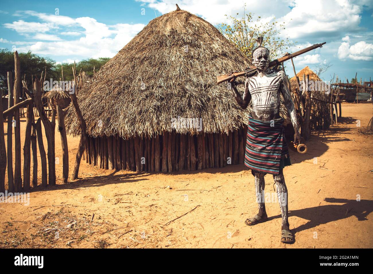 Homme avec corps peint tenant un fusil de chasse dans le village de la tribu Karo. Omo Valley, Éthiopie Banque D'Images