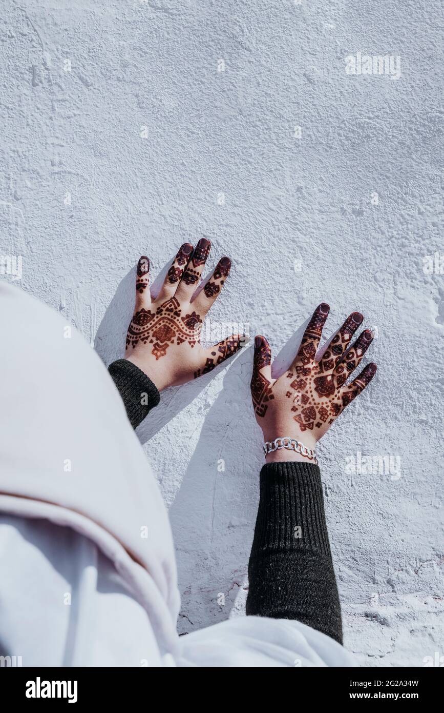Femelle ethnique non reconnaissable en vêtements traditionnels montrant les mains avec de beaux tatouages ornementaux Banque D'Images