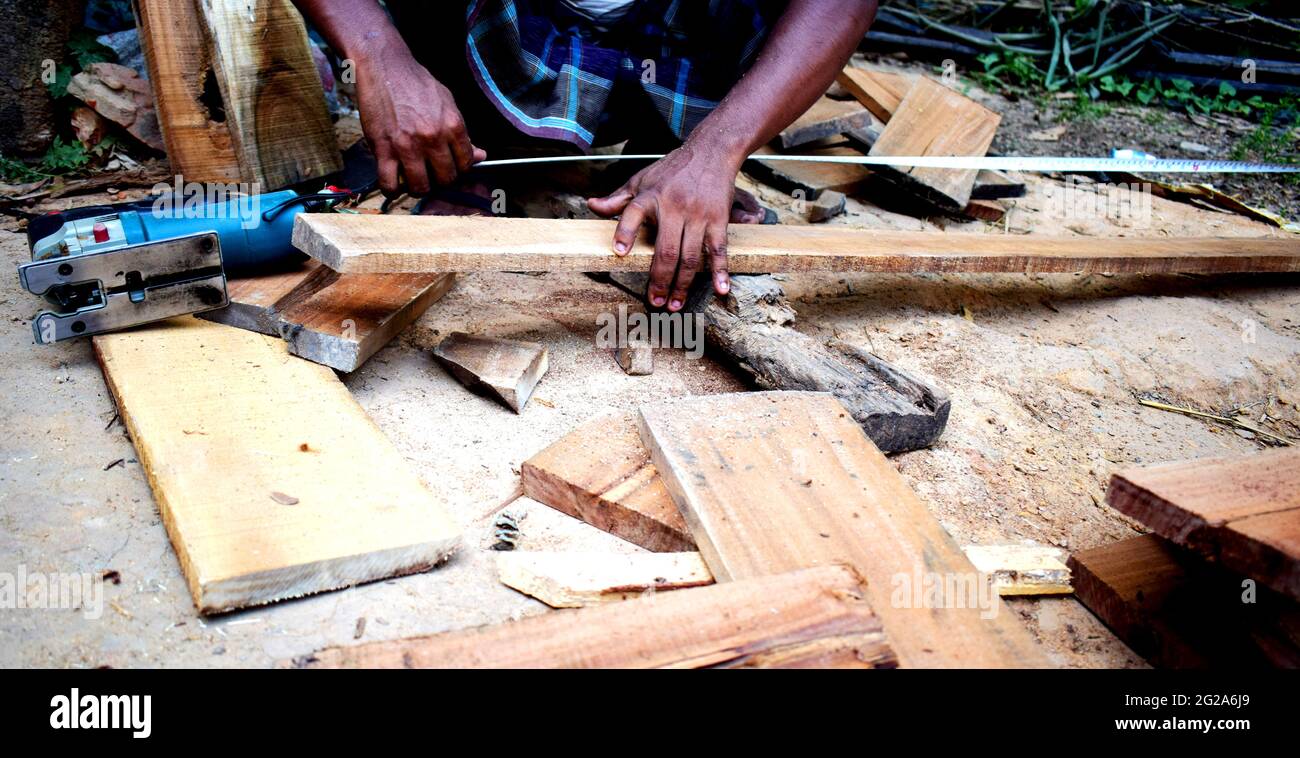 carpenter ccaucasien homme utilisant le mètre ruban regardant la taille du bois à l'espace de travail. profession d'artisan dans l'usine de bois. Banque D'Images