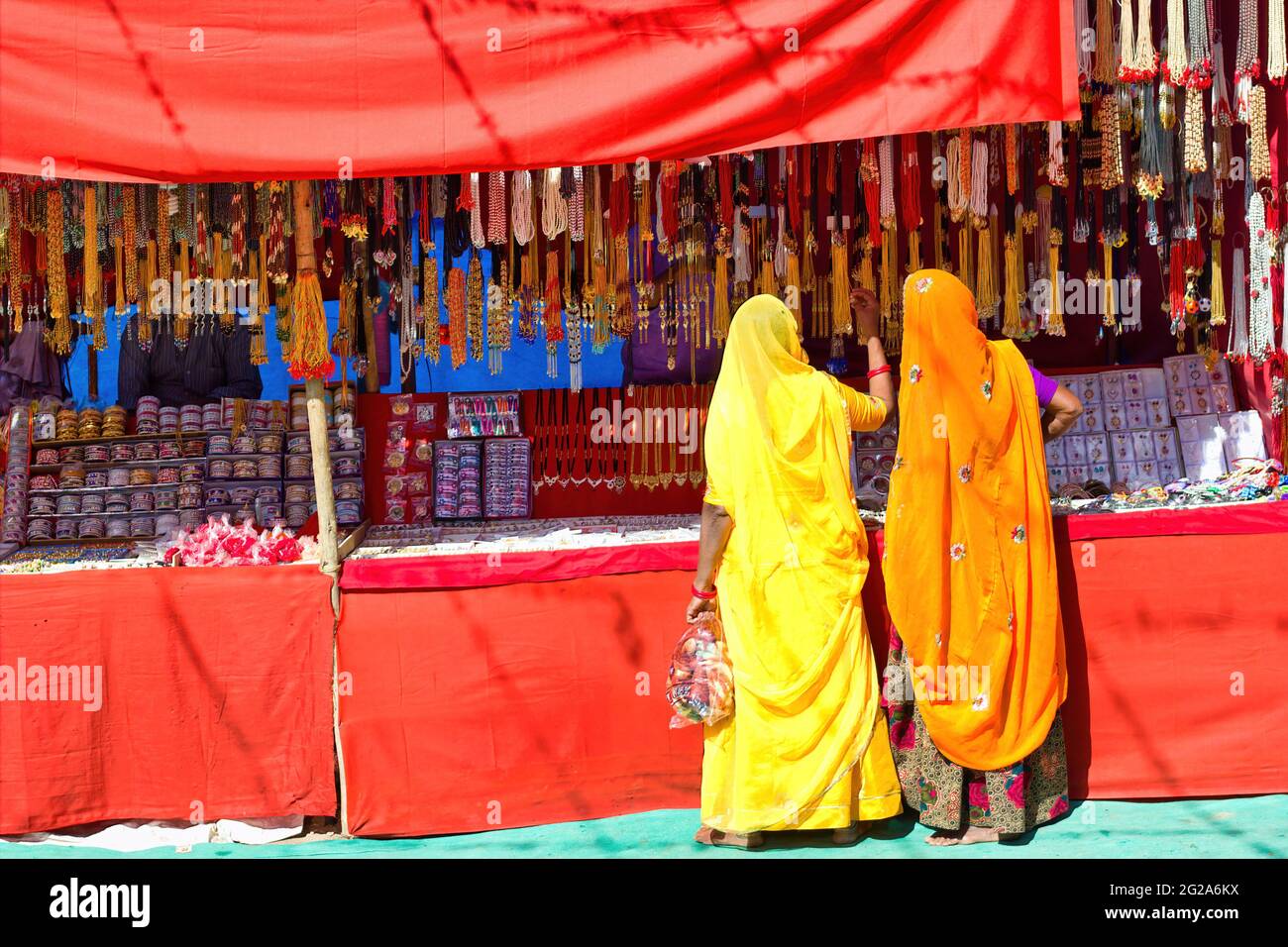Couple de femmes non identifiées dans la traditionnelle hindou de porter saree achat ou shopping bijoux articles dans la rue commerciale de Pushkar foire dans l'état de Ra Banque D'Images
