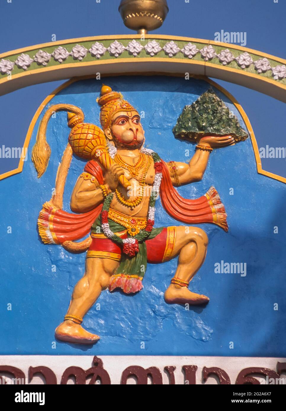 KERALA, INDE - représentation du dieu hindou Hanuman au-dessus de la porte du temple. Il lève la montagne herbacée comme preuve de force. Banque D'Images
